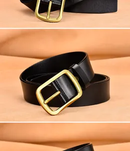 Detalle de cinturón de cuero negro con hebilla rectangular de latón en acabado mate