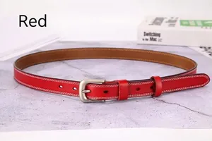 Close-up of red genuine leather thin belt with white stitching and silver buckle detail