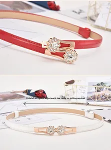 Detail of adjustable rhinestone sunflower buckle on slim red and white belts