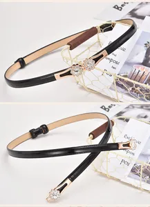 Detail of elegant black belt with golden twin flower buckle and sparkling rhinestones
