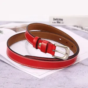 Detail of red leather narrow belt with matte silver buckle and white double stitching