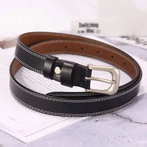 Detail of black leather belt with white double stitching and silver metal buckle pin