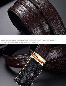 Close-up of brown crocodile texture belt with gold-edged automatic buckle and embossed detail