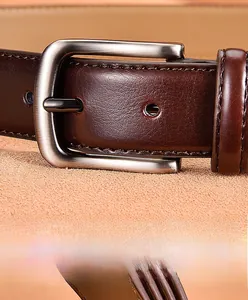 Gros plan d'une ceinture en cuir pour homme avec boucle argentée et coutures fines