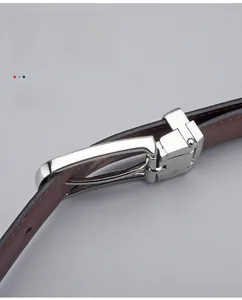 Dettaglio della fibbia ad ardiglione argento e cintura in pelle marrone scuro