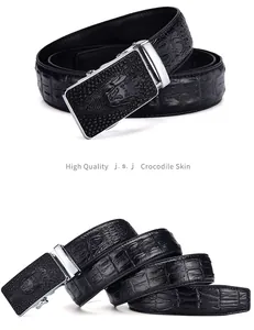 Close-up of black crocodile embossed leather belt with silver automatic buckle and logo