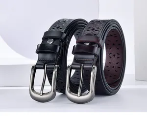 Detail of vintage hollowed-out floral patterns on black and burgundy leather belts