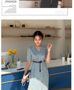 Fine ceinture en cuir noir avec boucle carrée dorée portée sur une robe fleurie