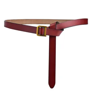 Détail d'une ceinture en cuir bordeaux avec boucle carrée dorée et texture raffinée