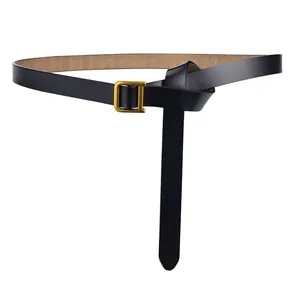 Détail de la fine ceinture en cuir noir avec une boucle en métal doré poli en forme de D
