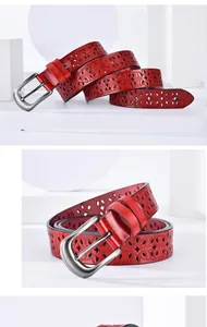Close-up of red hollowed-out leather belt with floral patterns and silver metal buckle