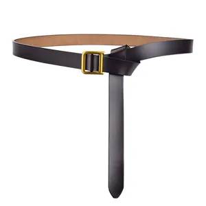 Détail de ceinture en cuir marron foncé avec boucle dorée en D sur fond blanc pur