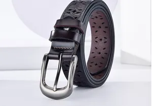 Detailed view of laser-cut hollow patterns and matte brushed metal buckle on leather belt
