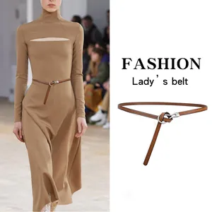Fashionable brown leather skinny belt for women with silver knot buckle on dress