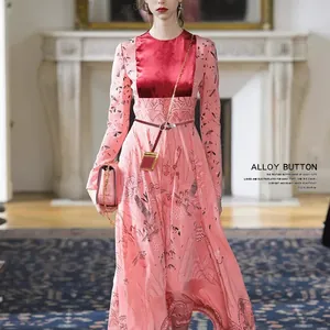 Detail of slim red leather belt with alloy button on pink floral printed dress