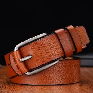 Close-up of brown leather belt with herringbone embossing and matte silver buckle