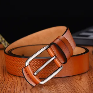 Macro shot of brown leather belt with woven texture and brushed silver needle buckle