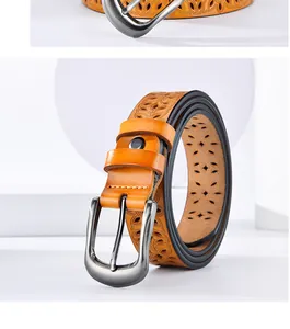 Detail of yellow-brown leather belt featuring laser-cut leaf patterns and silver buckle