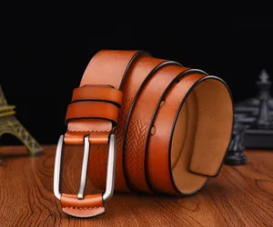 Macro view of men's brown leather belt with woven texture and silver metal buckle