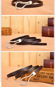 Detail of dark brown leather belt with horseshoe silver buckle on a rustic wooden backdrop