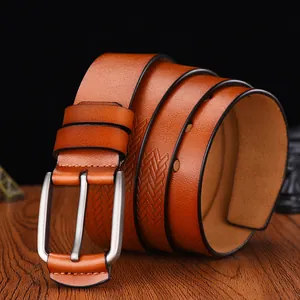 Brown leather men's belt with matte buckle and V-shaped textured pattern on wooden surface