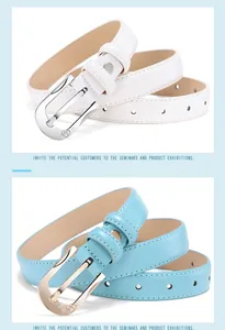 Detail of white and light blue slim leather belts with rhinestone heart-shaped buckles