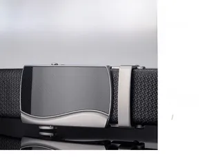 Macro detail of men's leather belt showing silver alloy buckle with textured wave pattern