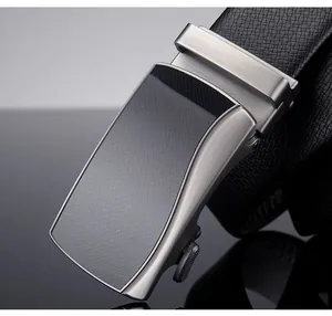 Close-up of men's black leather belt with brushed alloy automatic buckle and carbon fiber inlay