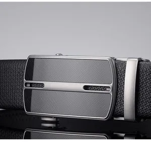 Macro detail of men's leather belt featuring a gunmetal automatic buckle with textured inlay