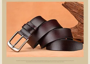 Detail of genuine brown leather belt with matte alloy buckle on a warm rustic wood backdrop