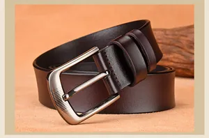 Close-up of vintage brown leather belt with matte texture and silver-gray pin buckle