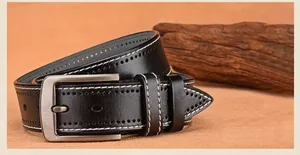 Close-up of black leather belt with white stitching and brushed metal buckle