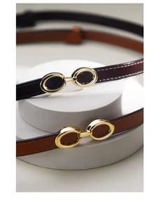 Detail view of thin leather waist belts with elegant gold interlocking buckles on display