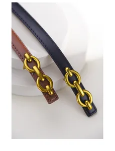 Detail of leather waist belts in black and brown with vintage gold interlaced metal buckles