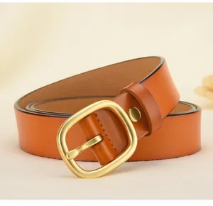 Gros plan d'une ceinture en cuir marron avec boucle dorée mate et couture de bordure