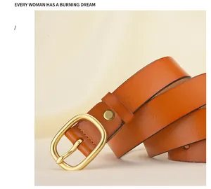 Gros plan d'une ceinture en cuir marron avec boucle dorée ovale sur tissu beige doux