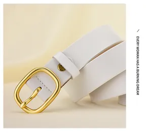 Détail d'une fine ceinture en cuir blanc avec boucle ovale en or mat élégante