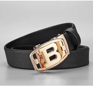 Detailed macro view of the golden B-letter automatic buckle on a black Saffiano belt