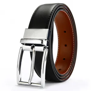 Detail of silver polished metal pin buckle on black leather belt with brown inner lining