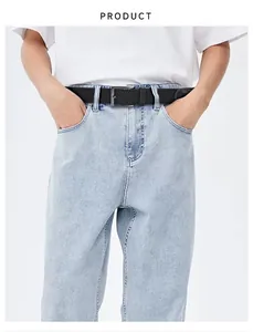 Détail d'une ceinture tressée noire pour homme avec boucle en alliage sur jean bleu