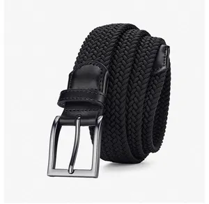 Détail d'une ceinture tressée élastique noire avec boucle métallique mate et bouts en cuir