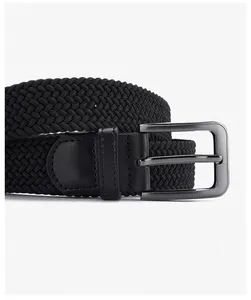 Close-up of black elastic woven belt with gunmetal needle buckle and leather joint detail