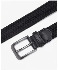 Detailed macro view of black elastic woven belt with grey metal pin buckle and leather stitching