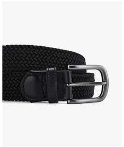 Detail of black woven elastic belt with matte gunmetal pin buckle and leather stitching