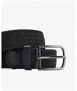 Vue macro de la ceinture tressée noire haute densité avec boucle en métal sombre et cuir