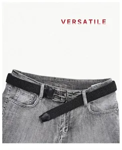 Nahaufnahme des schwarzen elastischen Flechtgürtels mit Legierungsschnalle auf grauer Jeans