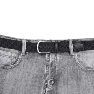 Elastic black braided belt with matte silver pin buckle on grey denim jeans