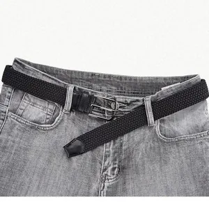 Ceinture tressée élastique noire avec boucle en alliage argenté sur un jean gris