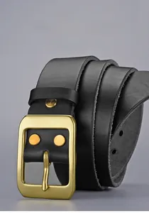 Détail de ceinture en cuir noir avec boucle dorée mate et rivets de style vintage