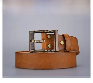 Macro detail of brown leather belt with vintage brass buckle and rustic bronze rivets